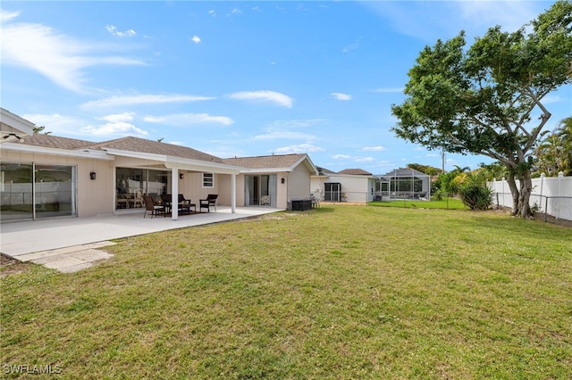 rear view of house featuring a yard, a patio, and a fenced backyard