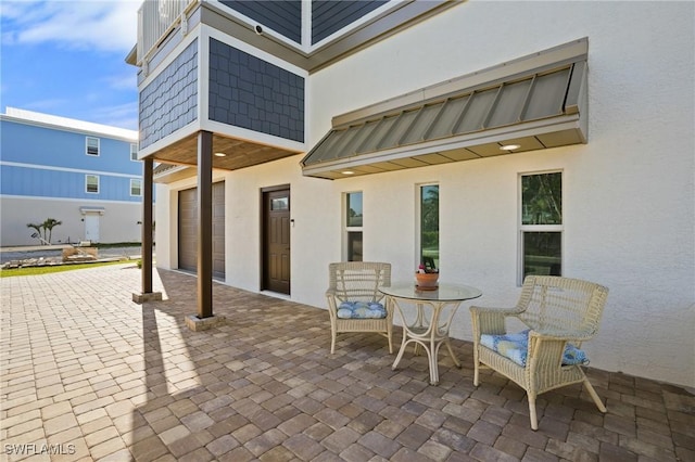 view of patio / terrace with decorative driveway and an attached garage