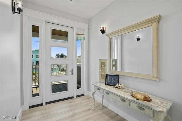 doorway to outside featuring light wood-type flooring and baseboards