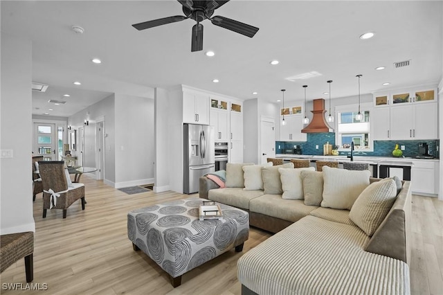 living area with recessed lighting, visible vents, and light wood-style flooring