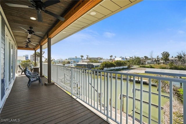 deck with a water view and a ceiling fan