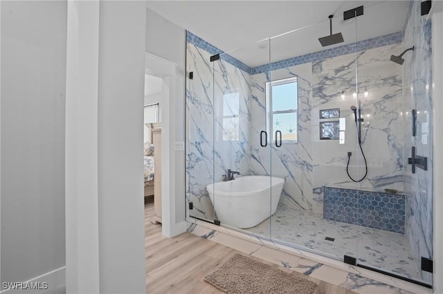 ensuite bathroom featuring a freestanding tub, a marble finish shower, connected bathroom, and wood finished floors