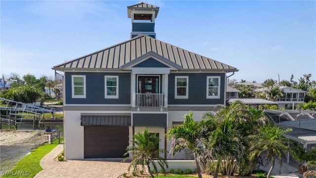 view of front of home with stucco siding, a standing seam roof, decorative driveway, an attached garage, and metal roof