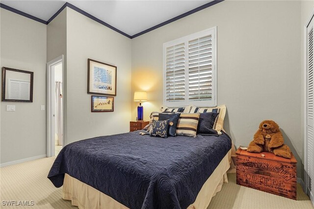 carpeted bedroom with crown molding and baseboards