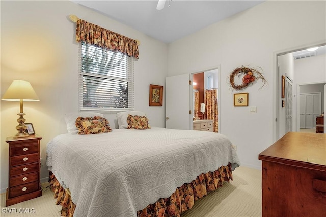 bedroom featuring ceiling fan, baseboards, ensuite bathroom, and light colored carpet