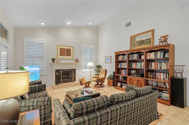 living area featuring recessed lighting, visible vents, a fireplace with raised hearth, high vaulted ceiling, and tile patterned flooring