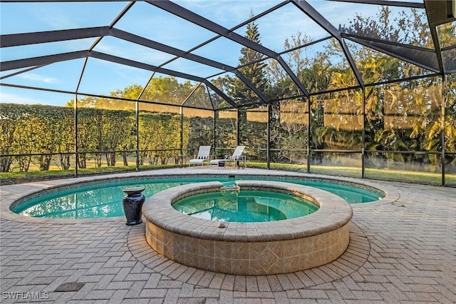 view of pool featuring glass enclosure, a patio, and a pool with connected hot tub