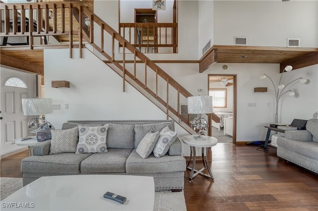 living area with stairway, wood finished floors, and visible vents