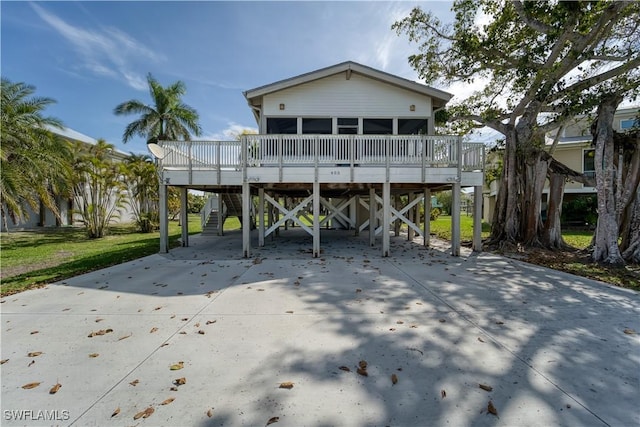 rear view of house with a carport, stairway, and a sunroom