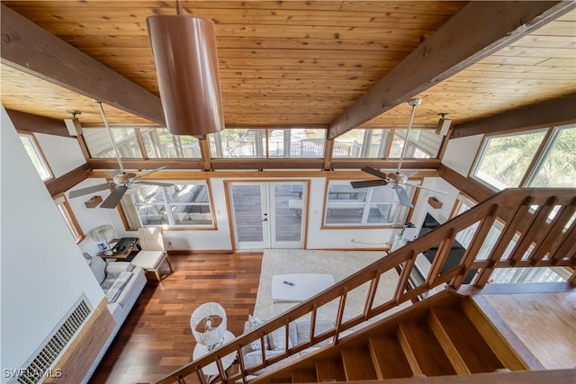 interior space with wood ceiling, beamed ceiling, wood finished floors, and a ceiling fan