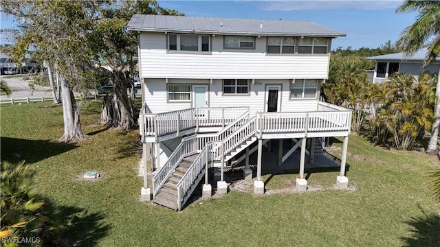 back of house featuring a wooden deck, stairway, metal roof, and a yard