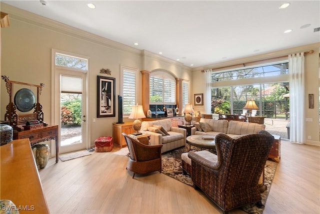 living room with light wood-type flooring, baseboards, ornamental molding, and recessed lighting