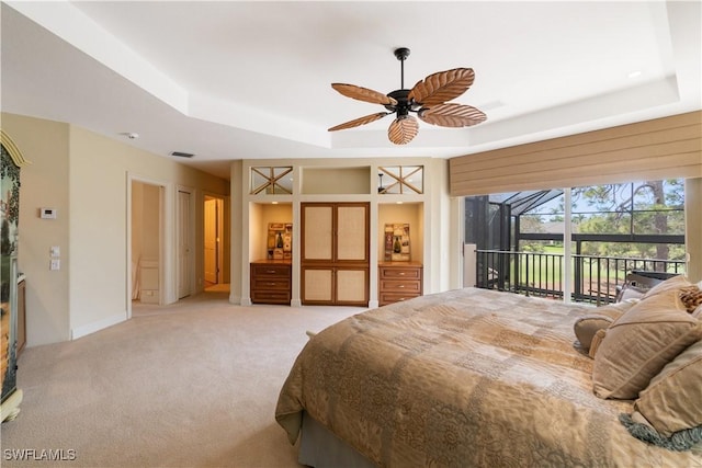 carpeted bedroom with a sunroom, access to outside, a raised ceiling, and visible vents