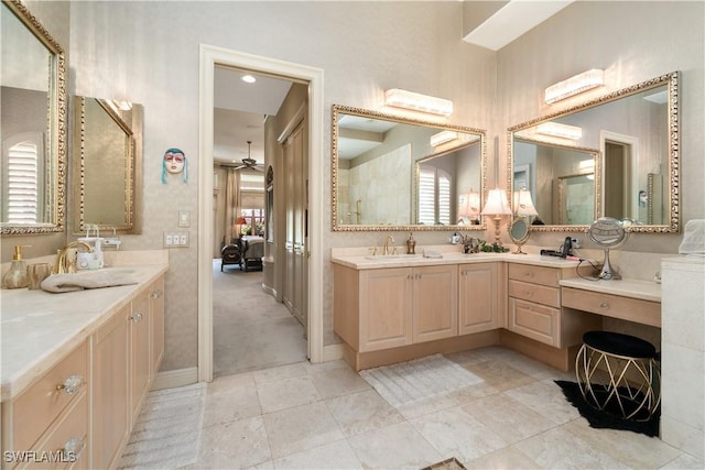 full bath with a ceiling fan, tile patterned flooring, two vanities, and a sink