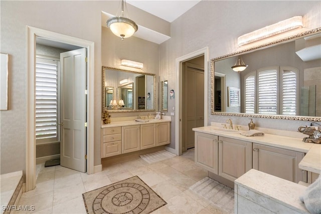 full bath featuring two vanities, a sink, and baseboards