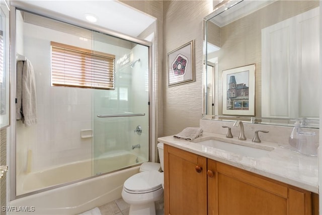 bathroom with enclosed tub / shower combo, vanity, tile patterned flooring, and toilet