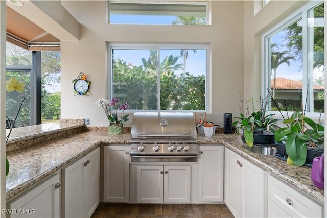 kitchen with light stone countertops and white cabinetry