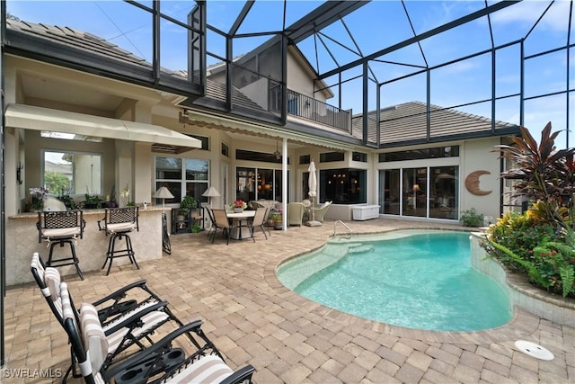 pool with a lanai, a patio area, and outdoor dry bar