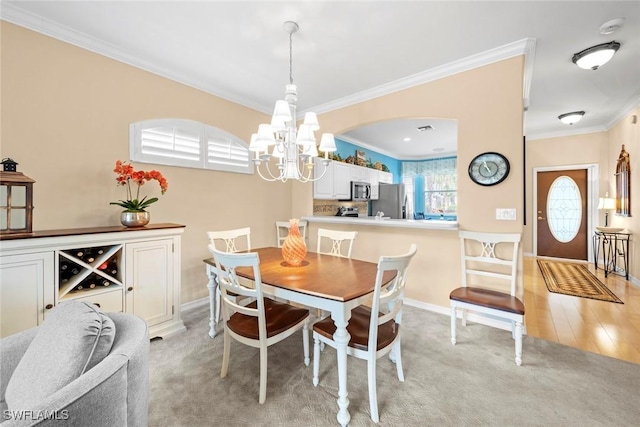 dining space featuring baseboards, ornamental molding, light colored carpet, and an inviting chandelier