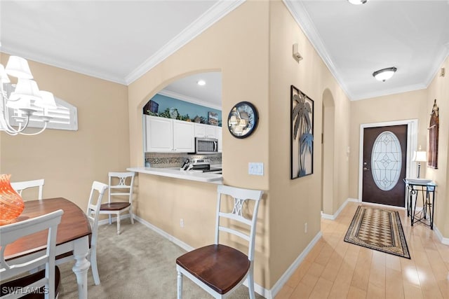 foyer featuring arched walkways, baseboards, and crown molding