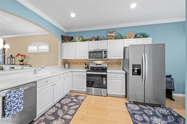 kitchen featuring light wood-style floors, white cabinetry, appliances with stainless steel finishes, and a sink