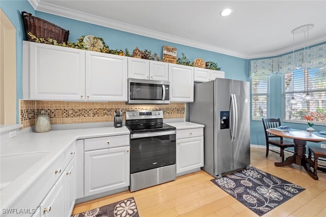 kitchen featuring tasteful backsplash, white cabinets, ornamental molding, stainless steel appliances, and light wood-type flooring