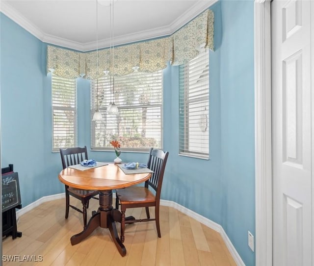 dining space with ornamental molding, baseboards, and wood finished floors