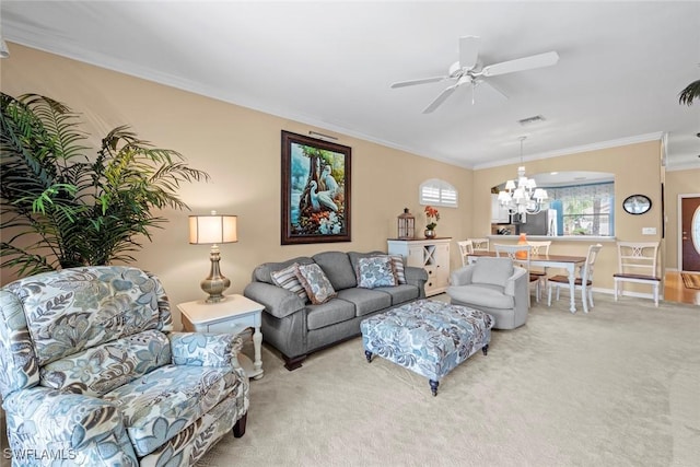 living room with ornamental molding, light carpet, visible vents, and ceiling fan with notable chandelier