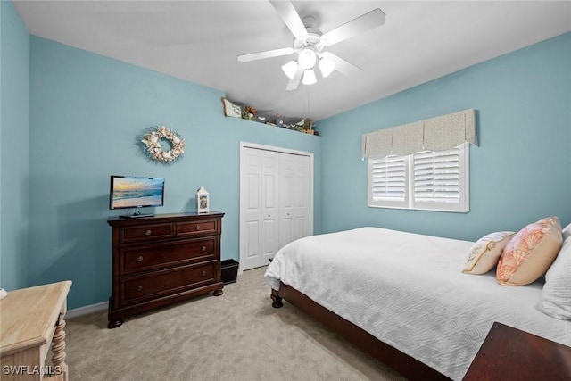 bedroom with a ceiling fan, carpet, a closet, and baseboards