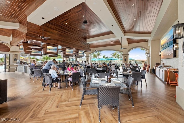 dining space featuring a towering ceiling, wooden ceiling, and a ceiling fan