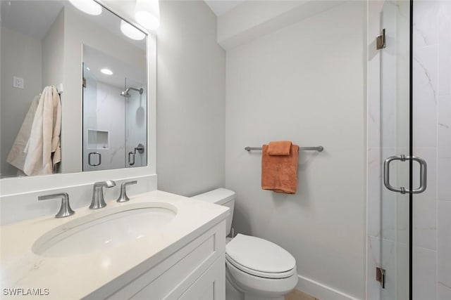 bathroom featuring baseboards, vanity, toilet, and a shower stall