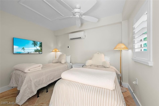 bedroom featuring attic access, a ceiling fan, baseboards, and a wall mounted air conditioner