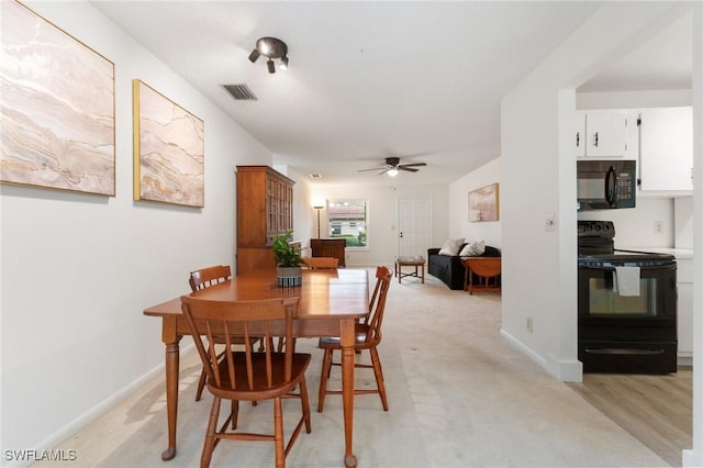 dining room with light carpet, baseboards, visible vents, and ceiling fan