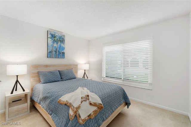 carpeted bedroom with a textured ceiling and baseboards