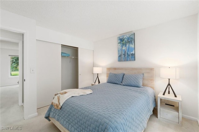 carpeted bedroom featuring a closet, a textured ceiling, and baseboards