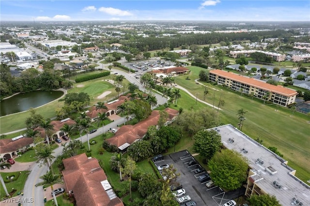 drone / aerial view with a water view and golf course view