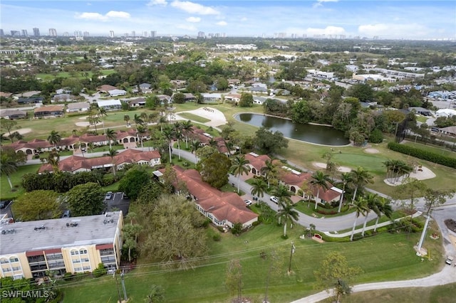 drone / aerial view with view of golf course and a water view