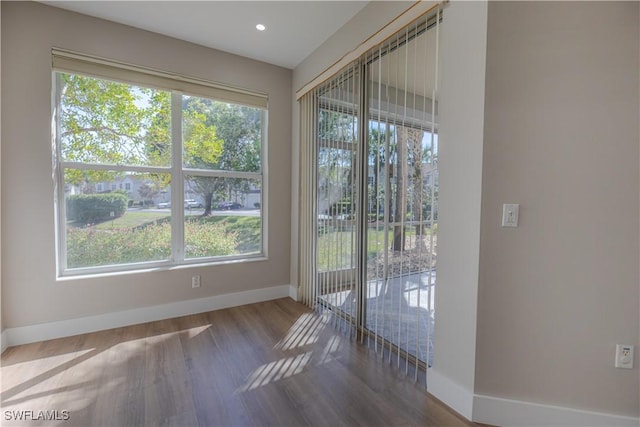 interior space with recessed lighting, wood finished floors, and baseboards