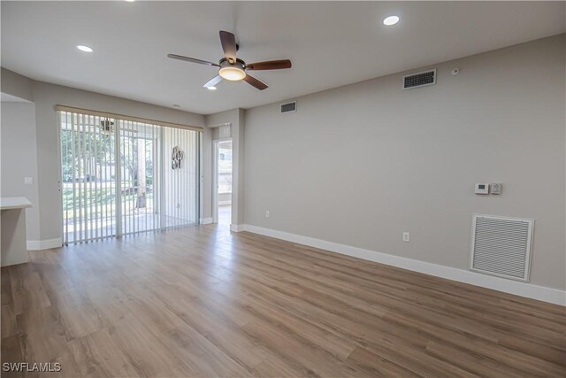 unfurnished room with visible vents, baseboards, and wood finished floors