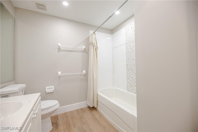 bathroom featuring toilet, shower / tub combo, wood finished floors, visible vents, and vanity