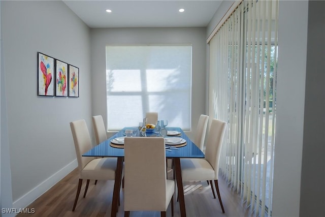 dining room with baseboards, wood finished floors, and recessed lighting