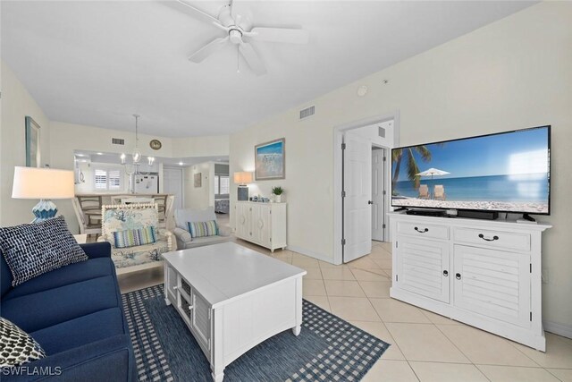 living room featuring light tile patterned floors, baseboards, visible vents, and a ceiling fan