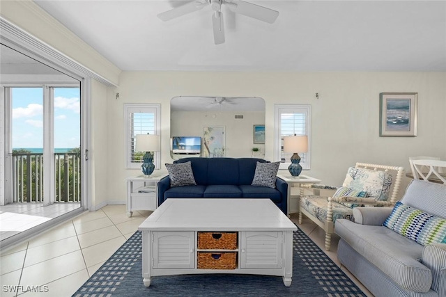 living area with ceiling fan, baseboards, and light tile patterned floors