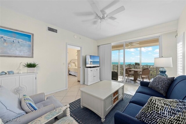 living room featuring visible vents, ceiling fan, baseboards, and light tile patterned floors