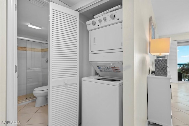 laundry room with stacked washer and dryer, laundry area, and light tile patterned flooring