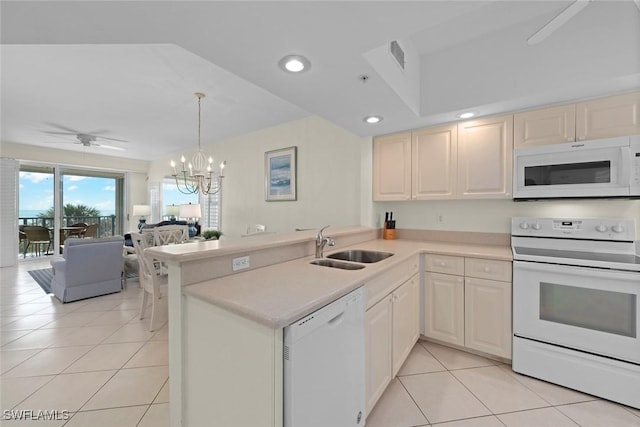 kitchen with a peninsula, white appliances, light tile patterned floors, and a sink