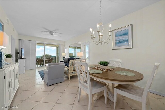 dining area with light tile patterned floors, ceiling fan with notable chandelier, and visible vents