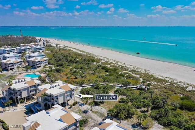 bird's eye view featuring a water view and a beach view