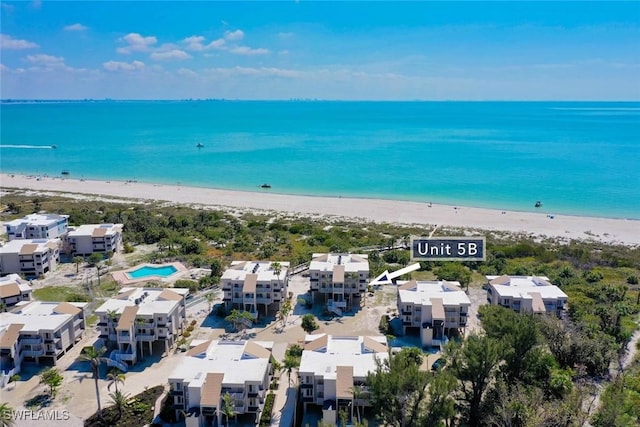 birds eye view of property featuring a water view and a beach view