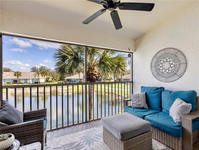 balcony with a water view and a ceiling fan